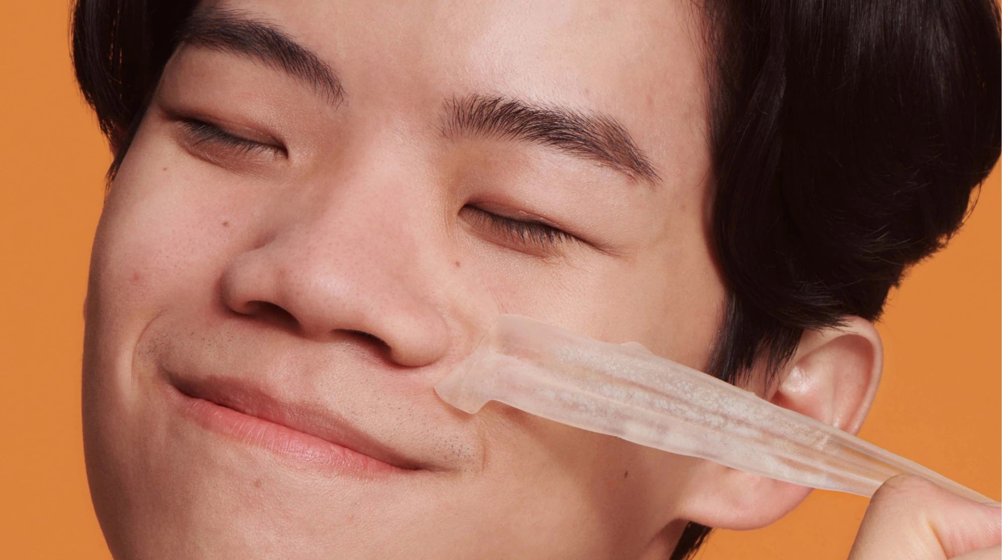 Man removes pimple patch from face.