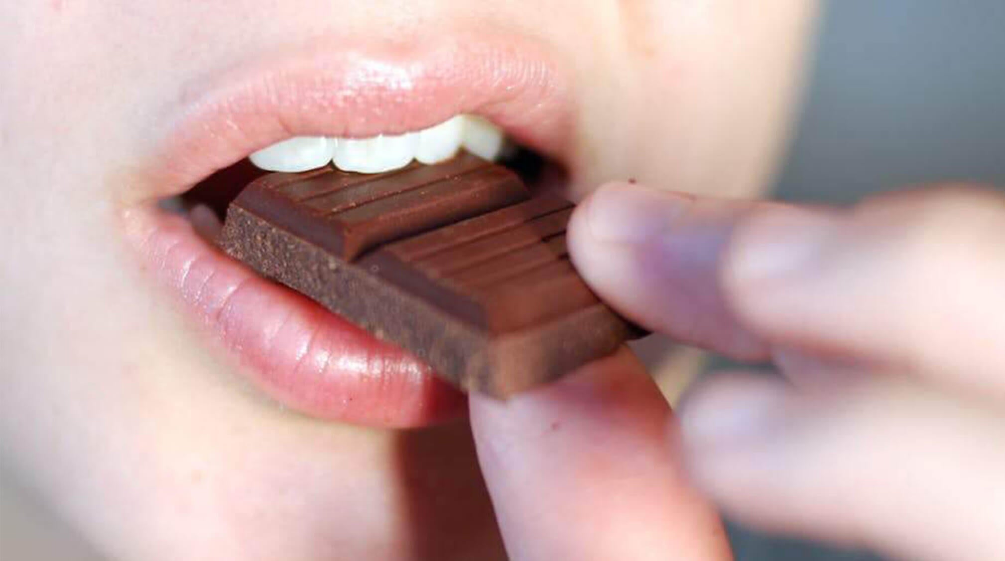 Image of person eating chocolate bar