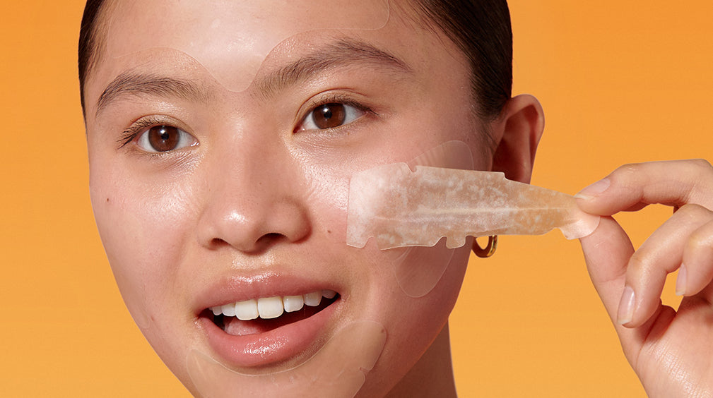 Female pulls acne patch off face.