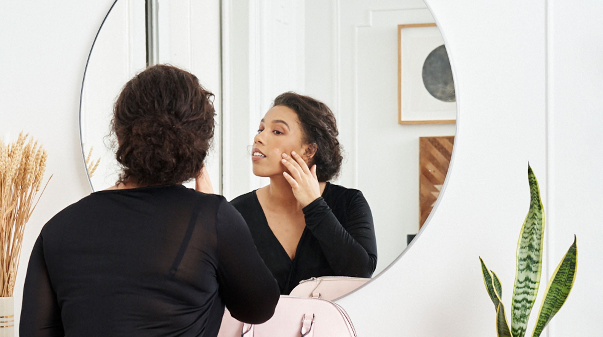Working woman checking out skin in front of mirror