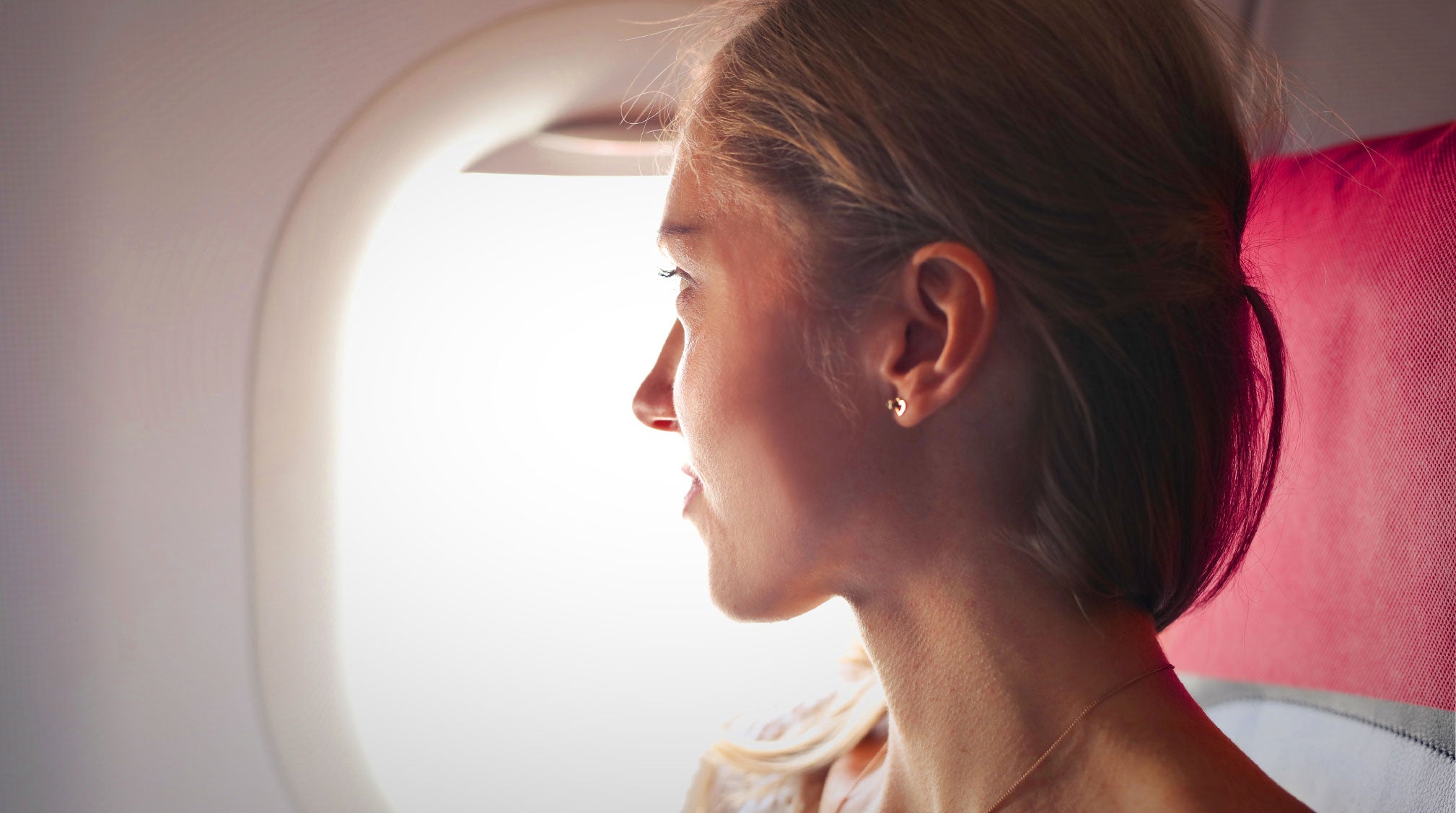 woman looking out the window on an airplane