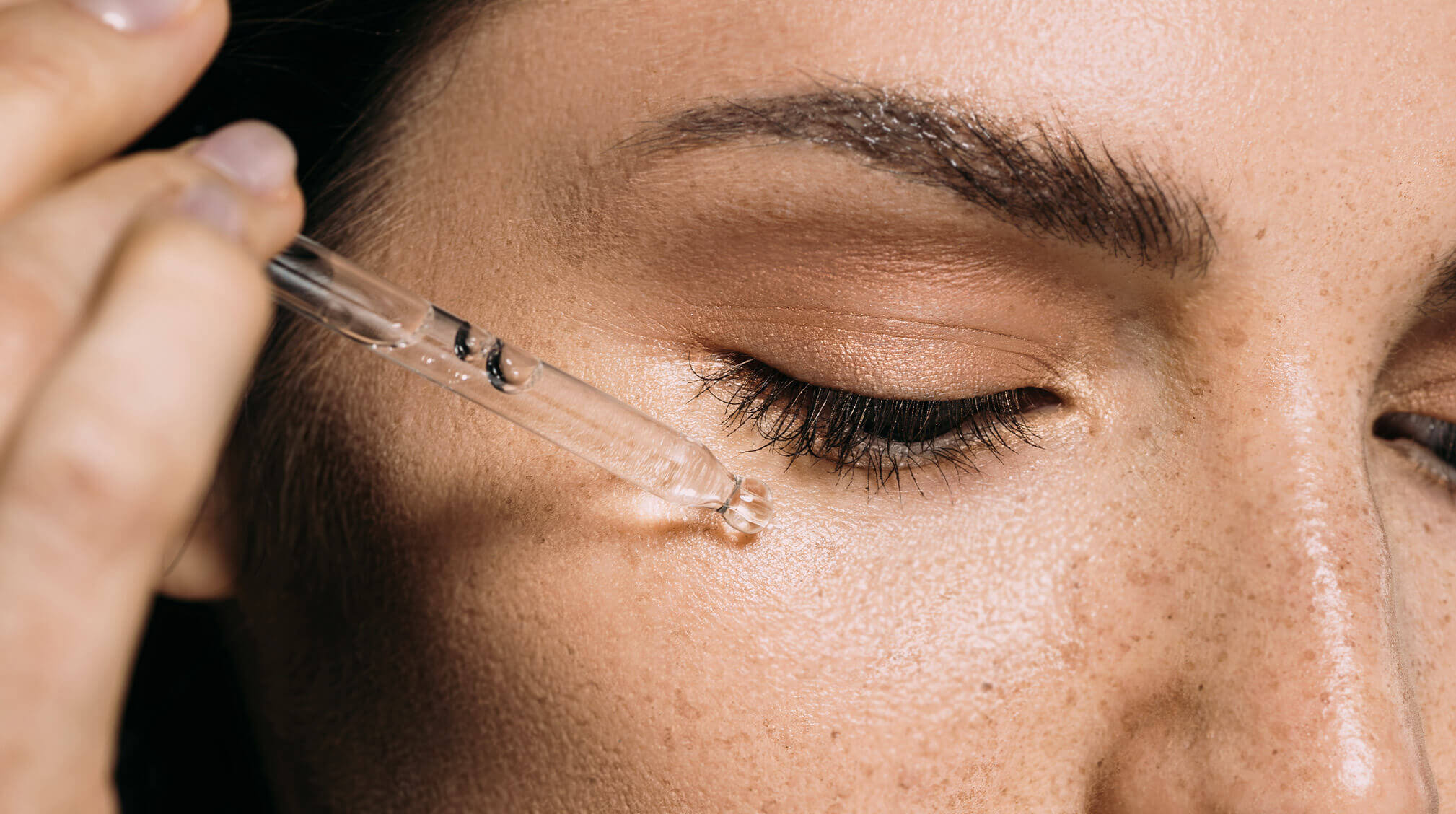 Woman applying hyaluronic acid serum on the face