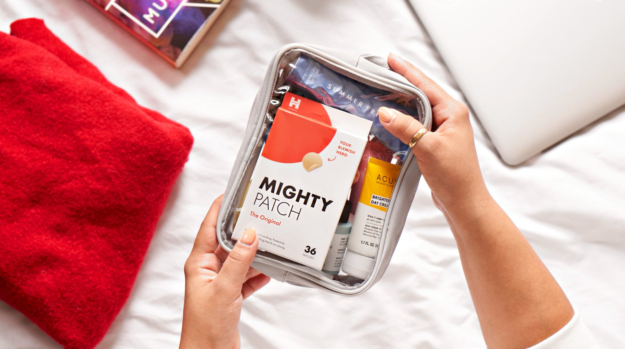Hand holding travel skincare bag with Mighty Patch Original
