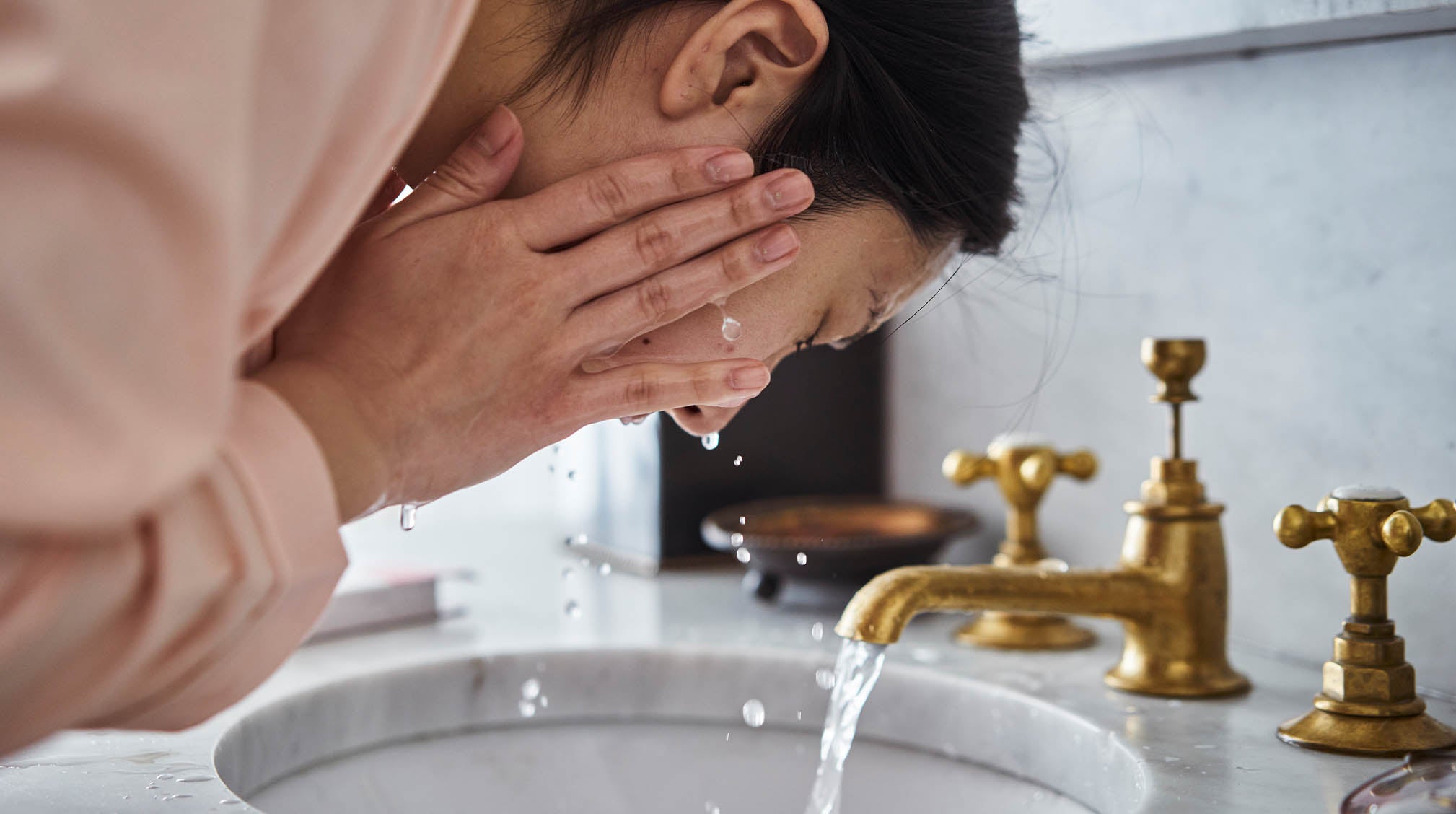 Asian woman washing face with foam cleanser